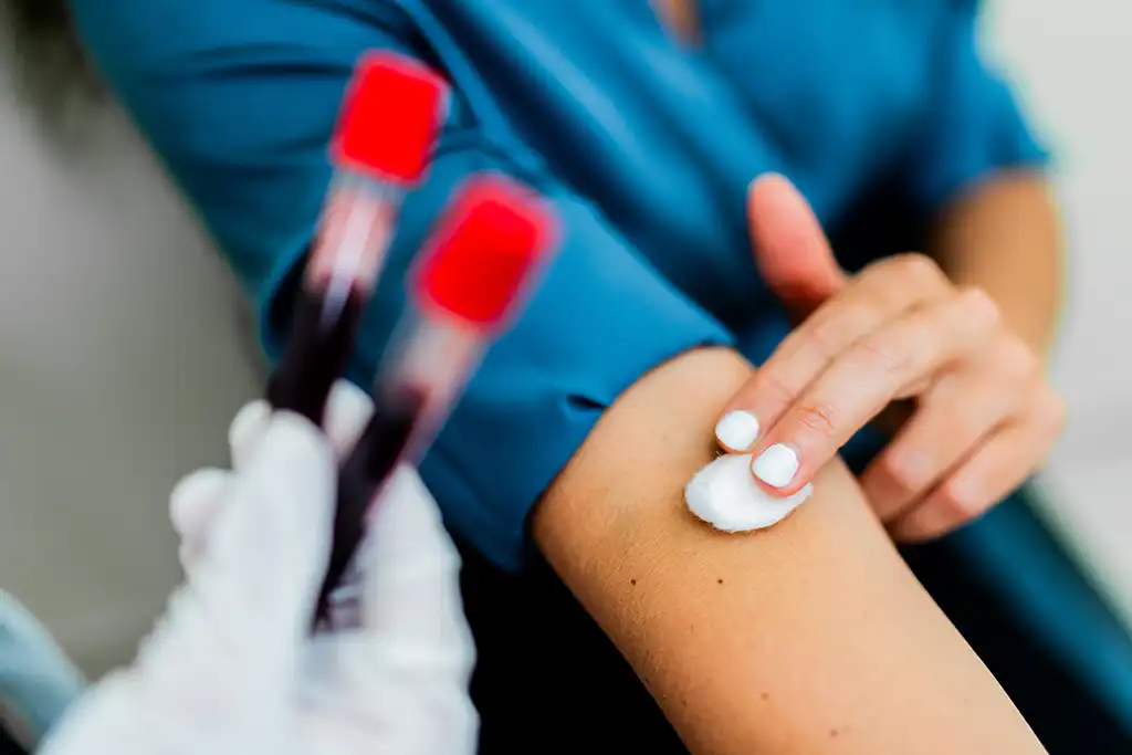 woman holding cotton ball after giving blood