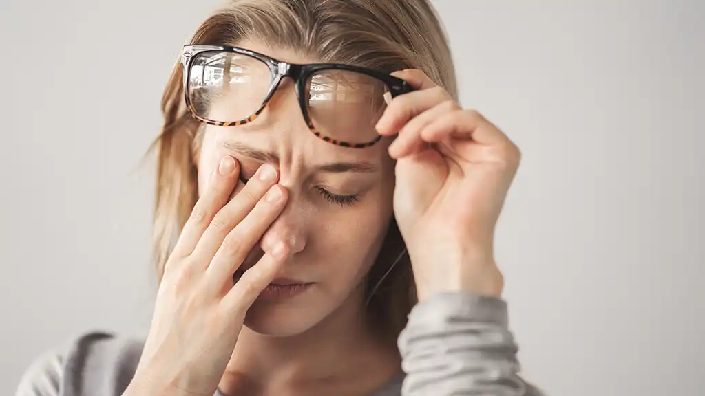 woman rubbing her eyes